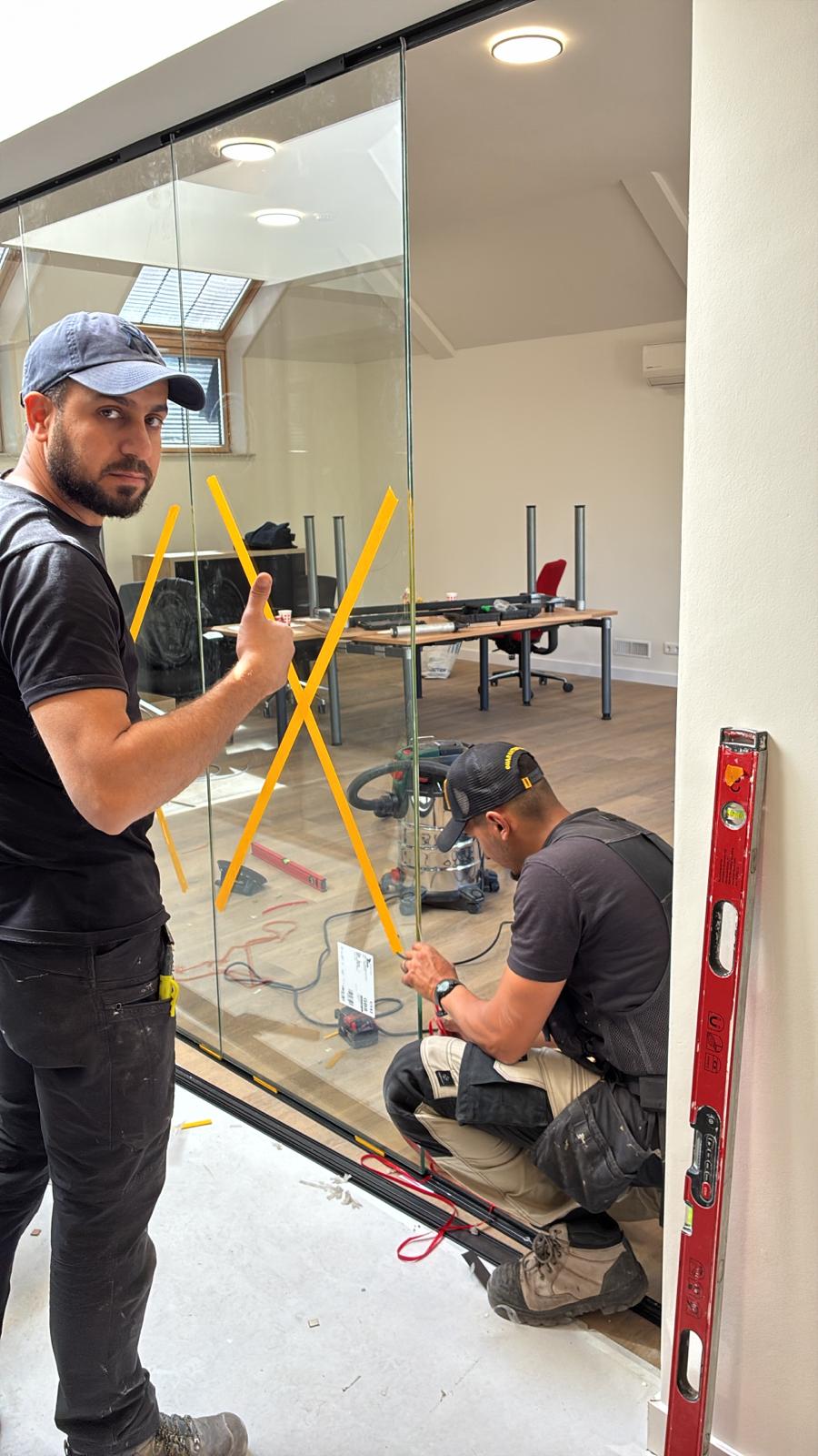 Installers fitting a glass sliding wall