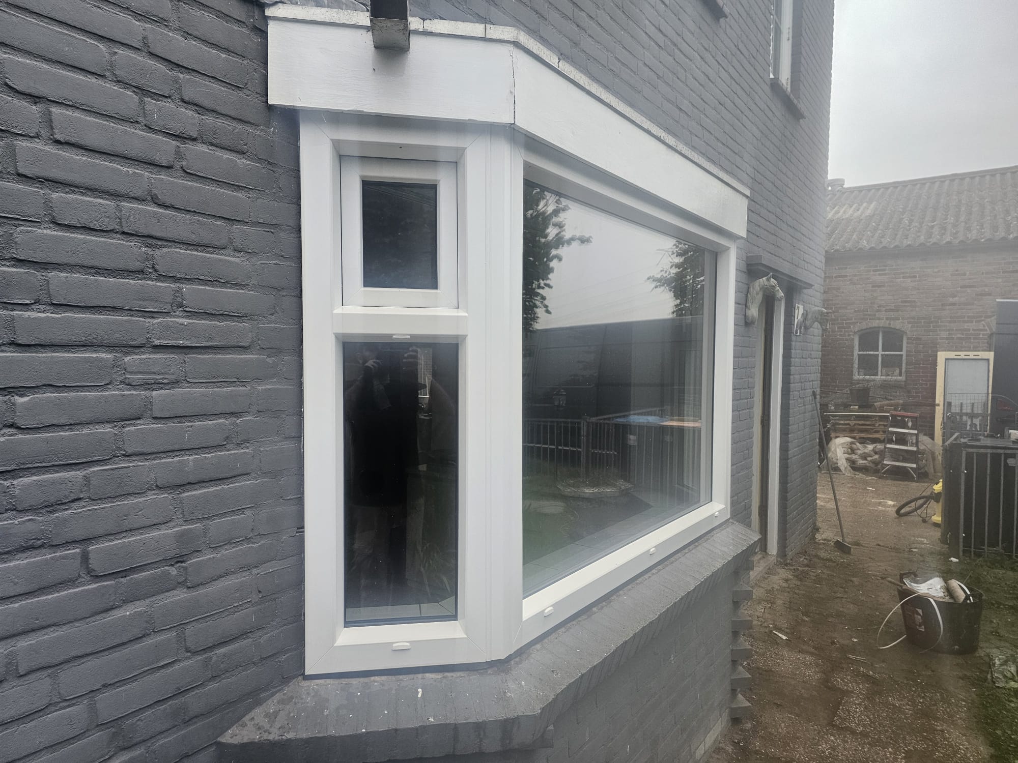 Nieuwe witte kunststof erker aan de buitenzijde van een woning in Tilburg