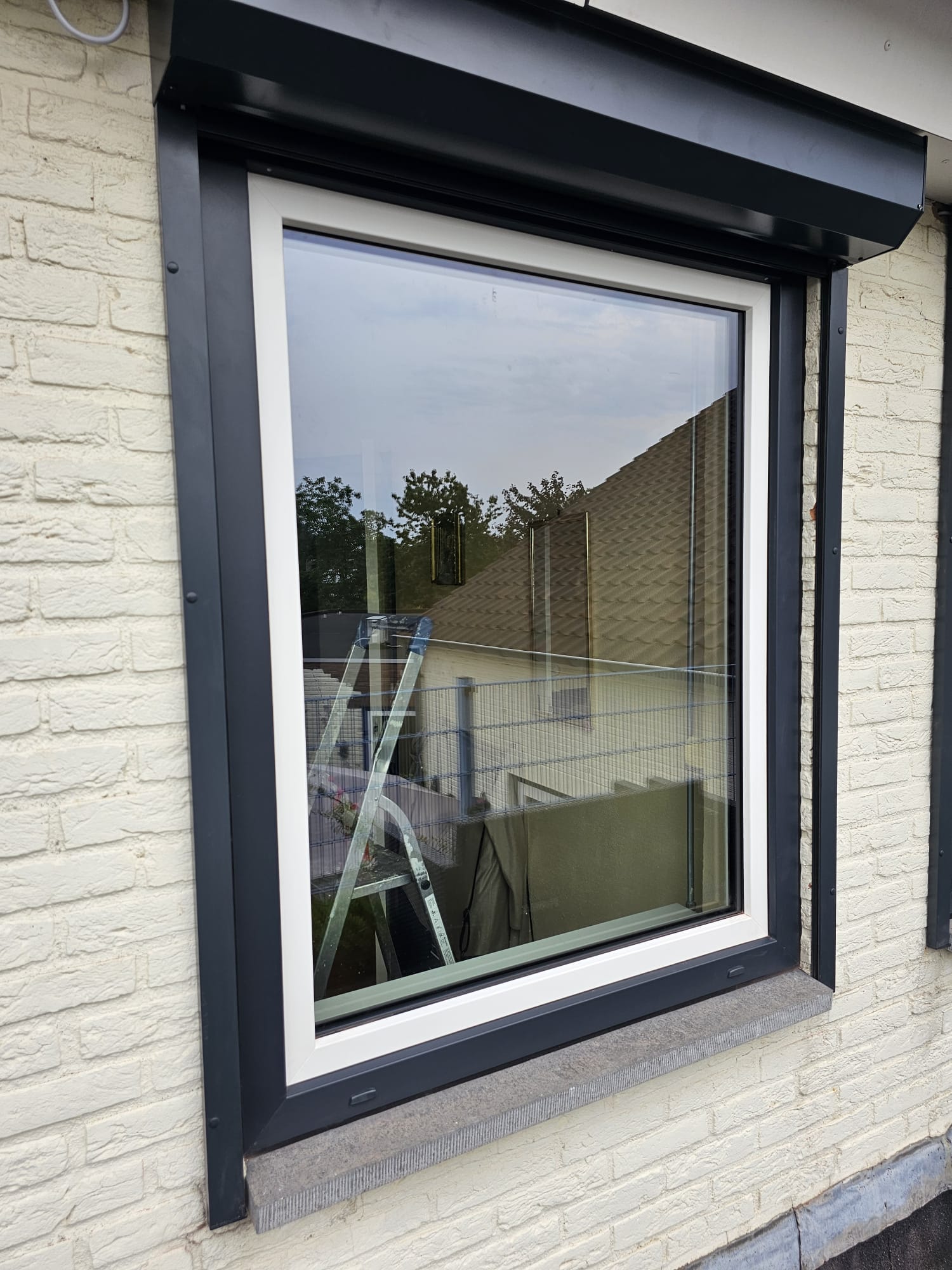 Large fixed anthracite uPVC window on the side elevation of a house in Veldhoven
