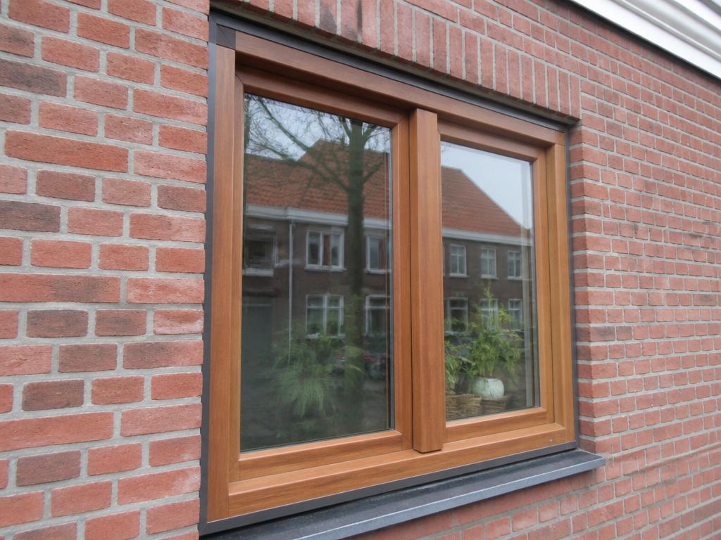 Houten kozijn met natuurlijke houtlook in een bakstenen gevel